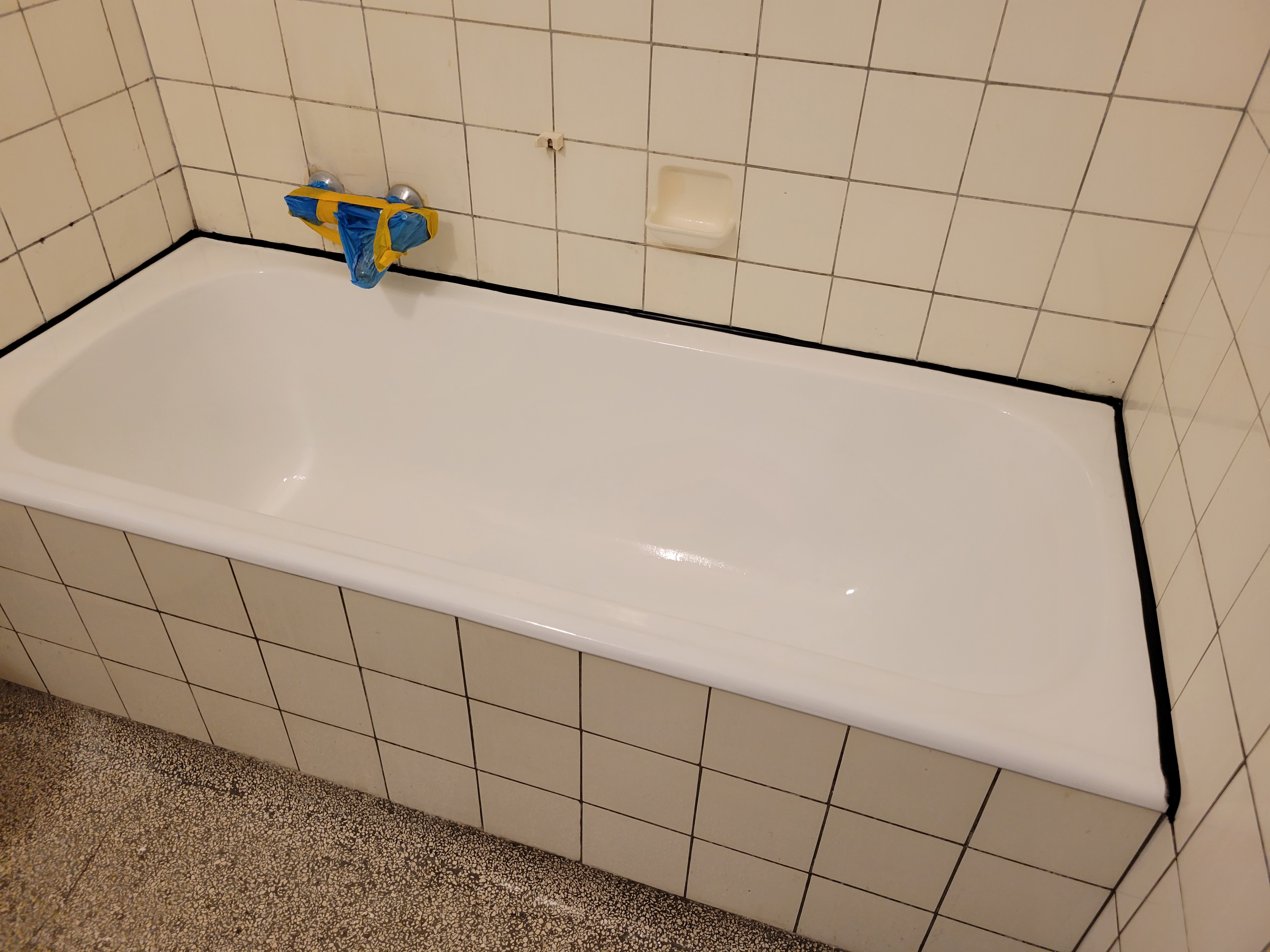 Etched bathtub reglaze with black caulking